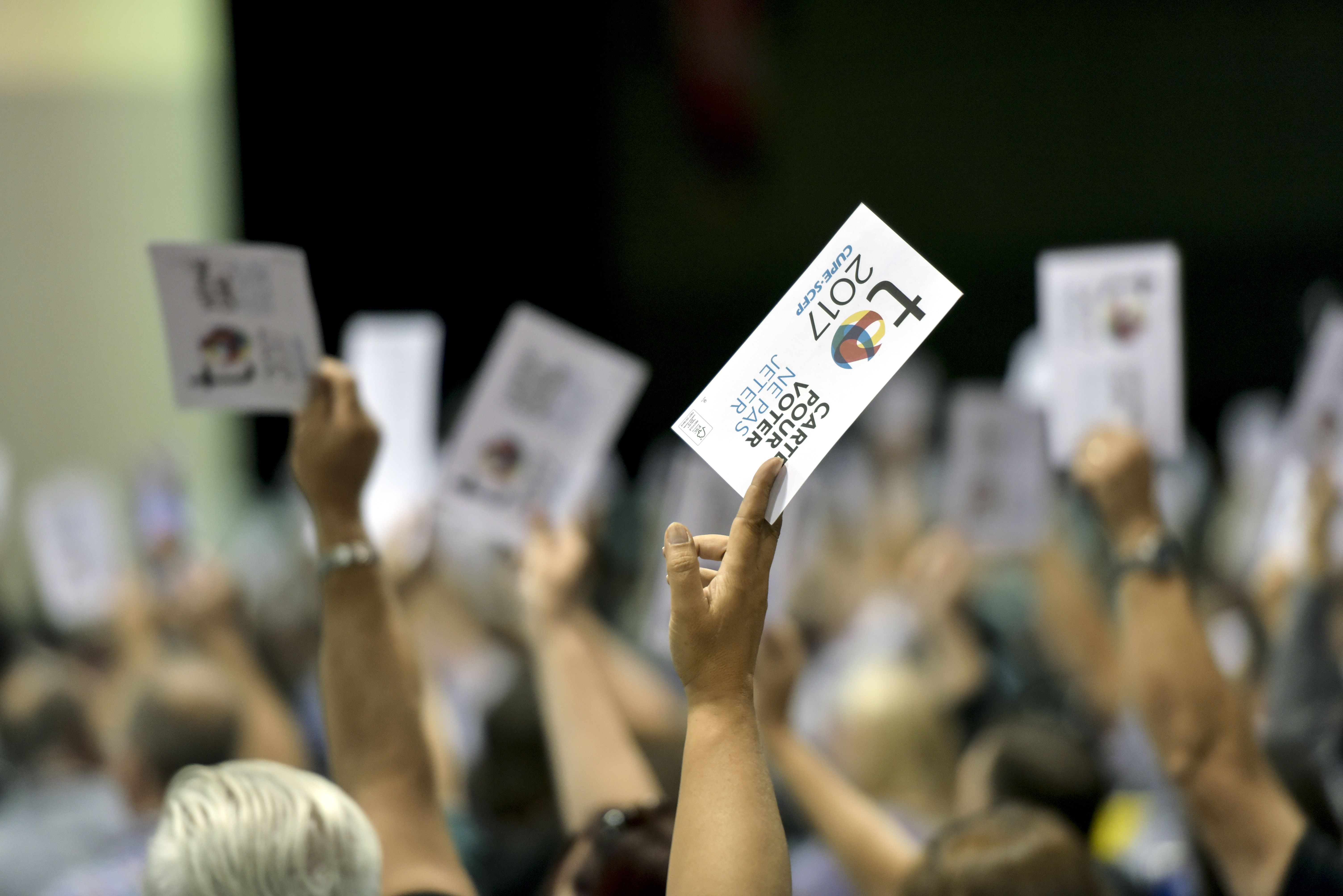 Delegates hold up voting cards at the CUPE National Convention
