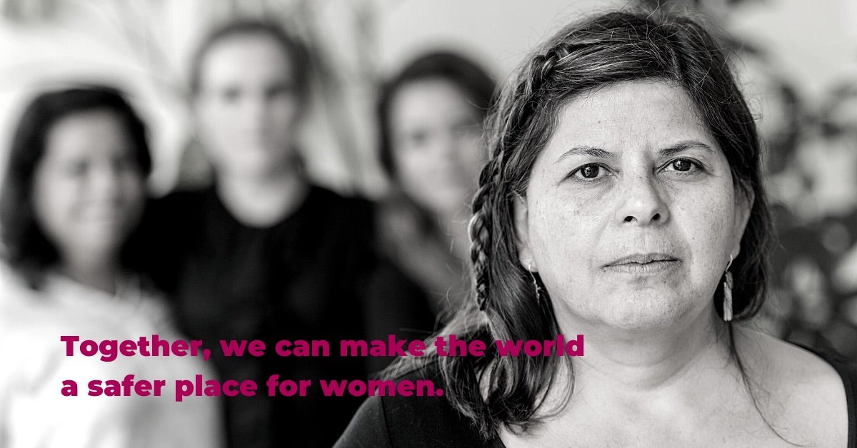 Black and white close-up photo of a woman with three other women in the background. Text: Together, we can make the world a safer place for women.