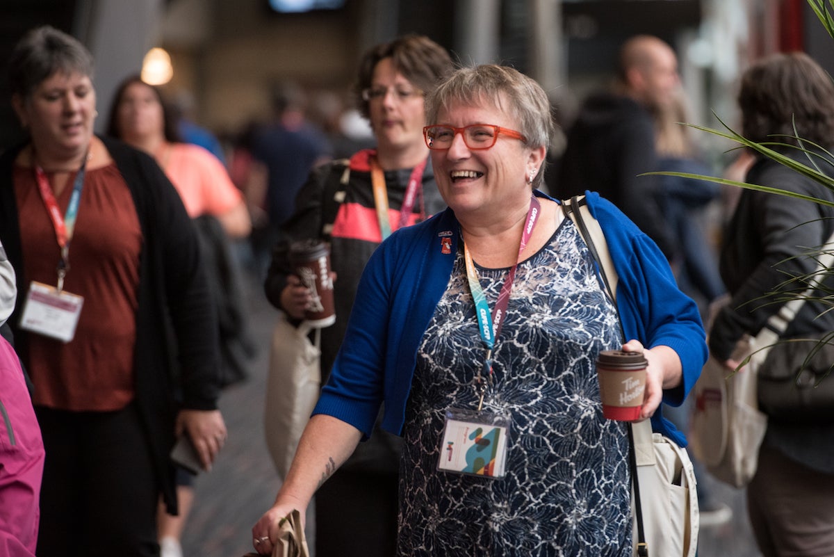 Photo of Nan McFadgen walking through crowd in a corridor at CUPE National Convention in 2019.